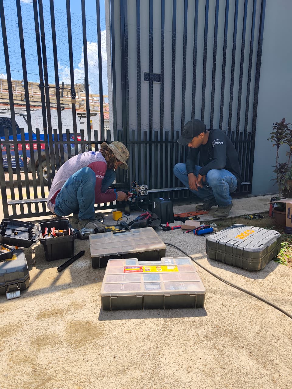 Técnicos da LS Security montando equipamento de automação de portão em campo