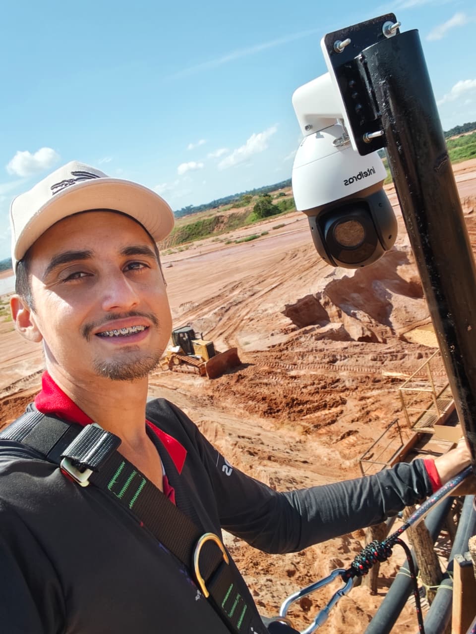 Técnico ao lado de câmera speed dome Intelbras instalada em poste na mineração